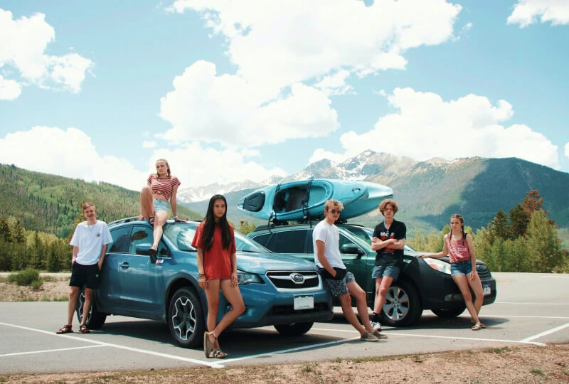 Group of friends with cars outdoors.
