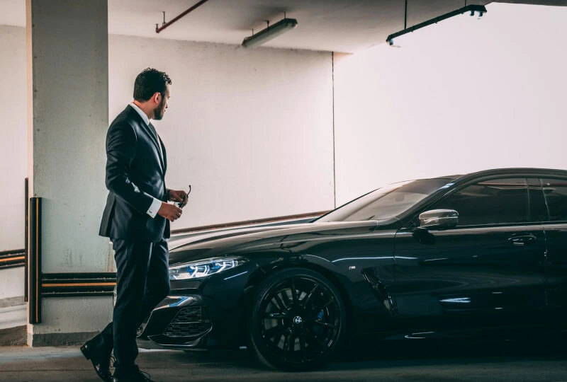 Man in suit near luxury car